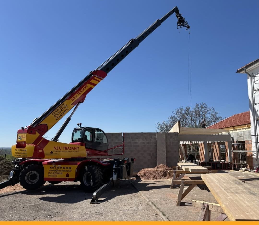 Chariot télescopique Neu Trasanit sur un chantier de charpente sous un ciel bleu